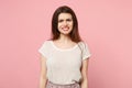 Displeased irritated young woman in casual light clothes posing on pastel pink wall background studio portrait
