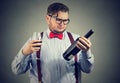 Displeased man looking at a bottle of red wine Royalty Free Stock Photo