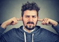 Displeased man plugging ears annoyed by loud noise Royalty Free Stock Photo