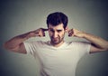 Displeased man plugging ears with fingers doesn`t want to listen Royalty Free Stock Photo