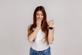 Displeased nervous woman with brown hair biting finger nails and looking at wrist clock with anxious Royalty Free Stock Photo