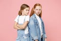 Displeased offended little kids girls 12-13 years old in t-shirt, denim clothes isolated on pink background. Childhood