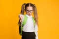 Displeased Schoolgirl Gesturing Thumbs Down In Dislike Posing In Studio