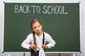 Displeased schoolgirl with heavy backpack near