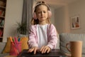 Displeased Schoolgirl Using Laptop Wearing Headphones Learning Online At Home