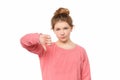 Close up displeased teen girl isolated on white background showing thumb down with negative expression Royalty Free Stock Photo