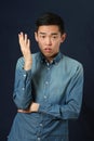 Displeased young Asian man gesturing with a hand Royalty Free Stock Photo