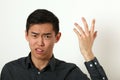 Displeased young Asian man gesturing with his hand Royalty Free Stock Photo