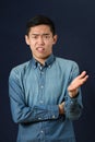 Displeased young Asian man gesturing with one hand Royalty Free Stock Photo