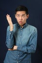 Displeased young Asian man gesturing with one hand Royalty Free Stock Photo