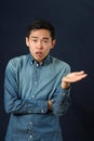 Displeased young Asian man gesturing with one hand Royalty Free Stock Photo