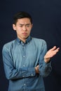 Displeased young Asian man gesturing with one hand Royalty Free Stock Photo