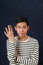 Displeased young Asian man gesturing with one hand Royalty Free Stock Photo