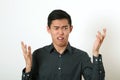 Displeased young Asian man gesturing with two hands Royalty Free Stock Photo