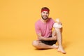 Displeased young bearded fitness sporty guy sportsman in headband t-shirt in home gym isolated on yellow background