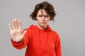 Displeased young brunette woman girl in casual red hoodie posing isolated on grey background studio portrait. People Royalty Free Stock Photo