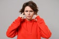 Displeased young brunette woman girl in casual red hoodie posing isolated on grey background studio portrait. People Royalty Free Stock Photo