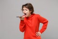 Displeased young brunette woman girl in casual red hoodie posing isolated on grey background studio portrait. People Royalty Free Stock Photo