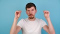 Displeased young man showing nonsense gesture, gossips indifference, dressed in white t-shirt