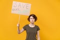 Displeased young protesting woman hold protest sign broadsheet placard on stick isolated on yellow background studio