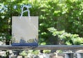 Disposable bag of kraft paper on a wooden table over nature background. Selective focus, copy space Royalty Free Stock Photo