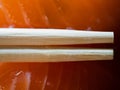 Disposable bamboo chopsticks and salmon sushi in background macro Royalty Free Stock Photo
