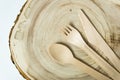 Disposable bamboo cutlery: spoon, fork, knife on a wooden plank.
