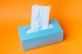 Disposable blue face mask box on orange background