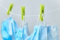 Disposable blue medical surgical mask hanging on peggs clothesline for reused after washing. Coronavirus, SARS-CoV-2 prevention.