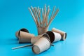 Disposable brown craft paper cups with paper straws on blue background. Eco-friendly tableware. Go green concept