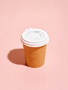 Disposable coffee cup on pink background.