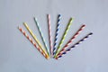Disposable colorful striped paper cocktail sticks for party on blue background. Eco friendly paper drinking straws. Royalty Free Stock Photo