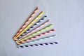 Disposable colorful striped paper cocktail sticks for party on blue background. Eco friendly paper drinking straws. Royalty Free Stock Photo