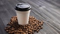 Disposable cup of coffee and coffee beans over dark wood background with space for your text Royalty Free Stock Photo