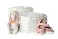 Disposable diapers, toy bunny and child`s shoes on background