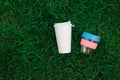 Disposable eco friendly coffee mug and refillable paper to go cup on green grass. Zero waste, plastic free, reusable