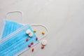Disposable face mask and pills on light background Royalty Free Stock Photo
