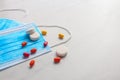 Disposable face mask and pills on light background Royalty Free Stock Photo
