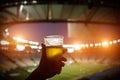 Disposable glass with beer. Soccer stadium on the background Royalty Free Stock Photo