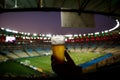 Disposable glass with beer. Soccer stadium on the background Royalty Free Stock Photo