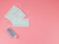 Disposable hygienic masks and alcohol gel hand sanitizer on pink background . protection against pm2.5 and COVID-19 concept