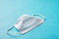 Disposable medical face mask on blue isolated background. Concept safety and health against coronavirus and over