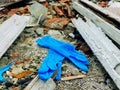 Disposable medical gloves on ground with other plastic trash on landfill. How to dispose used medical gloves right after Royalty Free Stock Photo