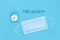 Disposable medical mask for protection against viruses and bacteria, pharmaceutical medicine pills and clock Royalty Free Stock Photo