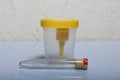 Disposable medical polymeric sterile container with a built-in holder for a vacuum test tube with a screw cap. Container for urine