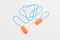 Disposable orange ear plugs on a white background