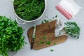 Disposable package with chopped fresh green parsley and dill or fennel on gray wooden table. Top view. Copy space. Harvesting Royalty Free Stock Photo