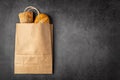 Disposable paper bag from a supermarket recyclable with whole baked loaves of bread flatlay on dark background with copy Royalty Free Stock Photo