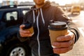 Disposable paper cup with hot drink. A man drinks coffee or tea and offers to share a drink with you Royalty Free Stock Photo