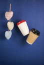 disposable paper flying coffee cups with textile hearts on a blue background hanging on. Takeaway coffee concept. I love coffee Royalty Free Stock Photo